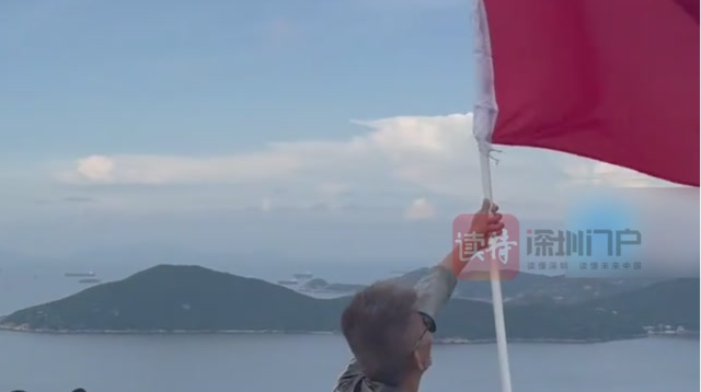 山东舰航母编队驶入香港，岸边群众挥舞国旗迎接