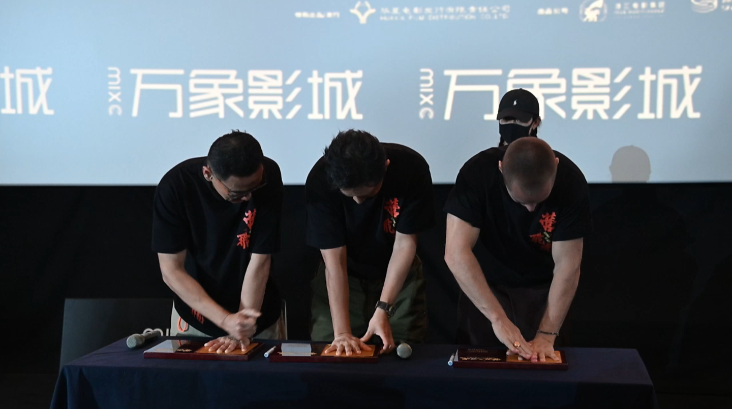 电影《营救飞虎》 深圳路演现场，主创团队在舞台上留下手印并签名