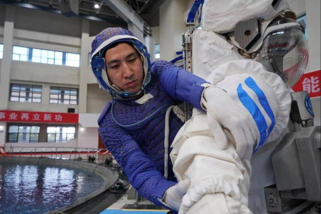△航天员武飞水下出舱活动训练前进入水下训练服