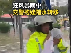 狂风暴雨中 交警抱娃蹚水转移