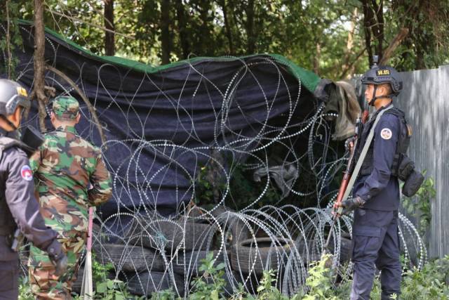 8月14日,在柬埔寨班迭棉吉省一个边境村庄,柬埔寨武装人员在铁丝网和轮胎旁执勤。新华社/柬新社 8月14日,在柬埔寨班迭棉吉省一个边境村庄,柬埔寨武装人员在铁丝网和轮胎旁执勤。新华社/柬新社