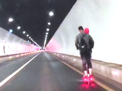 这对情侣溜着滑板车就进了大鹏迭福山隧道……