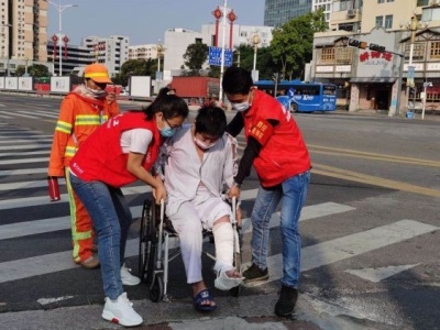 这张暖心照片被朋友圈大量转发：轮椅病人过路不便，志愿者热心帮扶